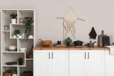 Mutfağın içinde beyaz tezgahlarda çatal bıçak var.