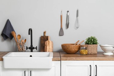 Mutfaktaki ışık duvarının yanındaki lavaboda çatal bıçak var.