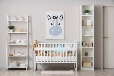 Beşik ve hayvan resimleri olan hafif çocukların yatak odasının içinde.