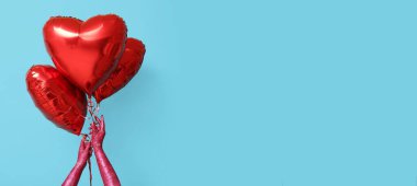 Mavi zemin üzerinde kalp şeklinde balonlar tutan parıltılı ellerle dolu. Sevgililer Günü kutlaması