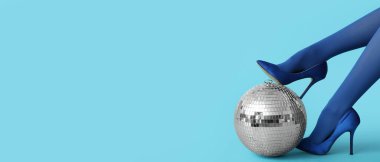 Yüksek topuklu kadın bacakları ve açık mavi zemin üzerinde disko topu metin için alan