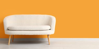 Turuncu duvarın yanındaki rahat beyaz kanepe. Tasarım için pankart