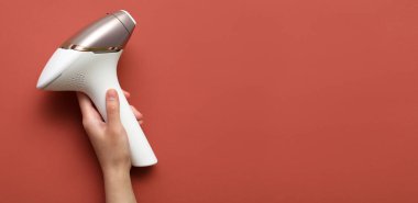 Kırmızı zemin üzerinde el ele tutuşan modern fotoepilatör metin için boşluk