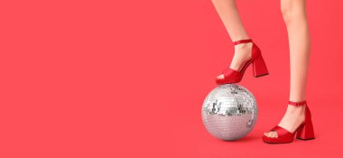 Güzel genç kadın bacakları ve kırmızı zemin üzerinde disko topu ve metin için boşluk.