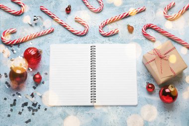 Açık mavi arkaplanda Noel süslemeleri olan boş bir defter