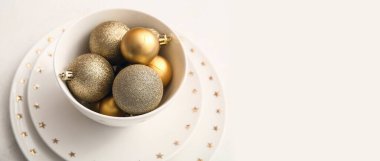 Beyaz zemin üzerinde Noel topları olan tabaklar ve kase ve metin için boşluk