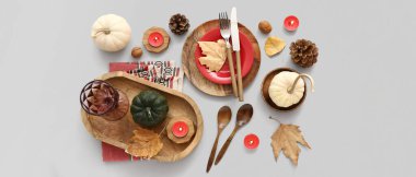 Gri arkaplanda balkabakları, kurumuş yapraklar ve mumlarla sonbahar masası ayarı