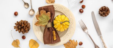 Beyaz zemin üzerinde balkabağı ve kurumuş yapraklar ile sonbahar masa ayarları