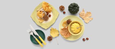 Açık arkaplanda kabak, koni ve kurumuş yapraklarla sonbahar masası ayarları