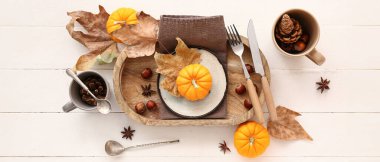 Beyaz ahşap arka planda balkabakları ve kurumuş yapraklarla sonbahar masası ayarı