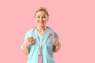 Pembe arka planda steteskobu olan kadın stajyer.