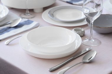 Temiz tabaklar ve çatal bıçak takımlarıyla Noel sofrası, yakın plan.