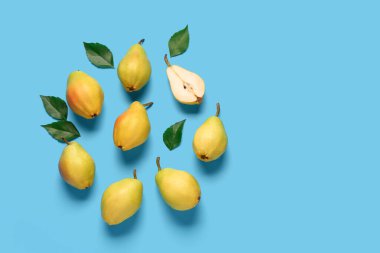 Mavi zemin üzerinde taze armutlar ve yapraklar