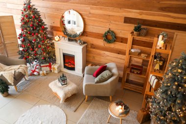 Noel ağacı, şömine ve koltukları olan şenlikli bir oturma odası.