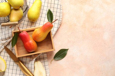 Bej arka planda olgun armutlarla ahşap kutu.