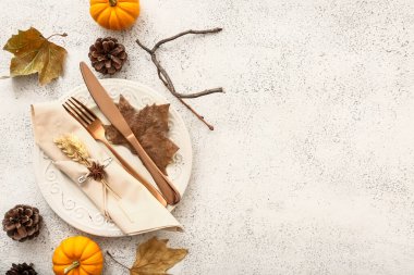 Beyaz arkaplanda balkabakları, koniler ve kurumuş yapraklarla sonbahar masası ayarları