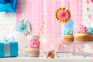 Masanın üzerinde beyaz tuğlalarla süslenmiş lezzetli kekler. Cinsiyet ortaya çıkan parti kavramı