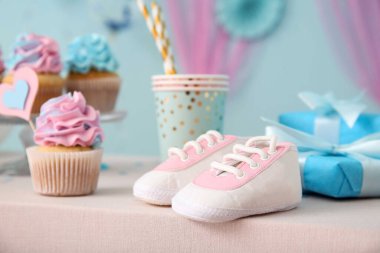 Masada mavi arka planda bebek paçası ve süslemeleri olan enfes kekler. Cinsiyet ortaya çıkan parti kavramı