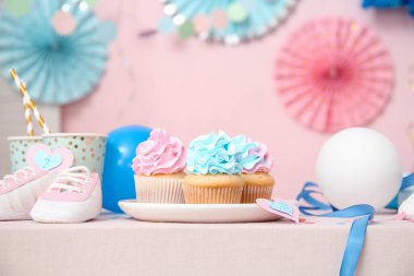 Bebek poposu ve masa üzerinde pembe arka planda süslemeleri olan enfes kekler. Cinsiyet ortaya çıkan parti kavramı