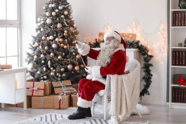 Noel Baba Noel arifesinde evde mektup okuyor.