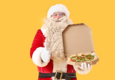 Noel Baba 'nın sarı arka planda bir kutu lezzetli pizzası var.