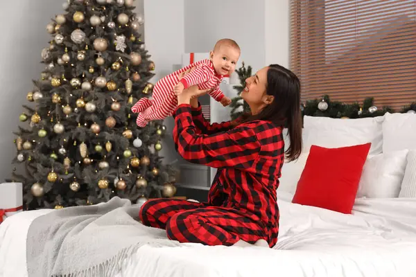 Genç anne ve tatlı bebek Noel arifesinde evdeler.