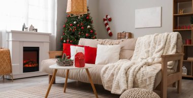 Kanepesi, masası, Noel ağacı ve şöminesi olan bir oturma odası.
