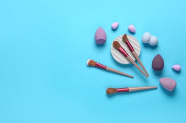 Mavi arkaplanda makyaj süngerleri ve fırçalar