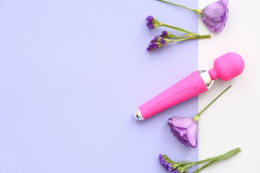 Seks dükkanından pembe vibratör ve arka planda güzel çiçekler.