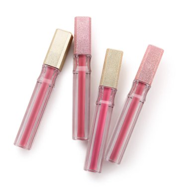 Beyaz arka planda farklı tonlarda güzel sıvı pembe rujlar.