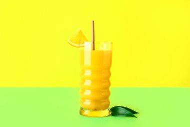 Bir bardak taze portakal suyu ve renkli yapraklar.