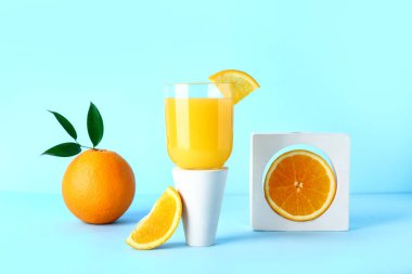 Mavi arka planda bir bardak taze portakal suyu ile dekoratif podyum