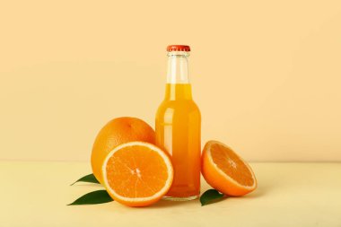 Bir şişe taze portakal suyu ve renkli yapraklar.