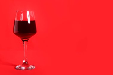 bir bardak şarap kırmızı zemin üzerine