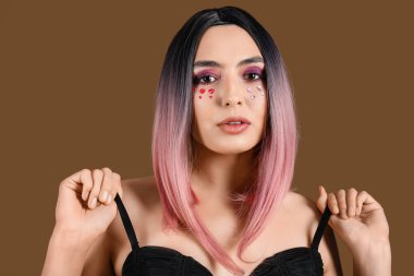 Kahverengi arka planda güzel makyajlı peruklu genç bir kadın. Sevgililer Günü kutlaması