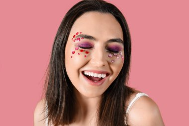 Pembe arka planda güzel makyajlı mutlu genç bir kadın. Sevgililer Günü kutlaması