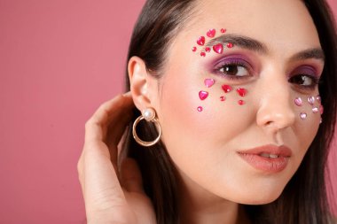 Pembe arka planda güzel makyajlı genç bir kadın. Sevgililer Günü kutlaması