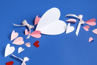 Mavi arkaplanda Sevgililer Günü için farklı kağıt kalpler içeren kompozisyon