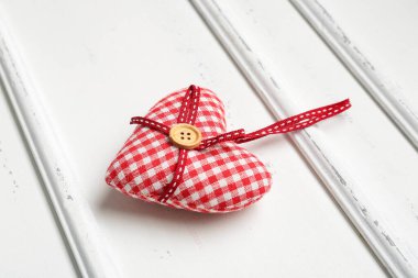 Sevgililer Günü için yumuşak ahşap arka planda kumaş kalp, yakın plan.