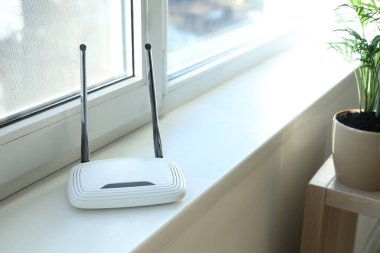 Modern Wi-Fi yönlendirici pencere kenarında, aydınlatma odasında, yakın plan