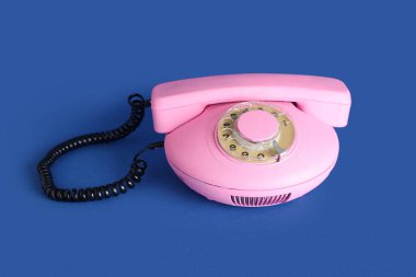 Mavi arkaplanda pembe retro telefon