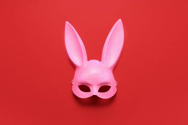 Kırmızı arkaplanda pembe tavşan maskesi