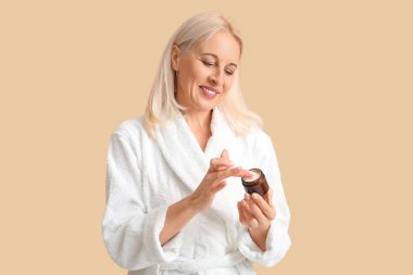 Bornozlu, krema kavanozlu, renkli bir kadın.