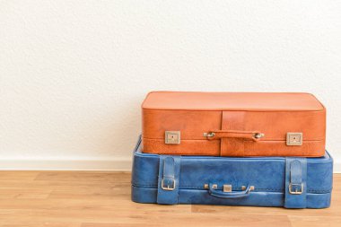 Kahverengi ve mavi retro deri bavullar odada yerde