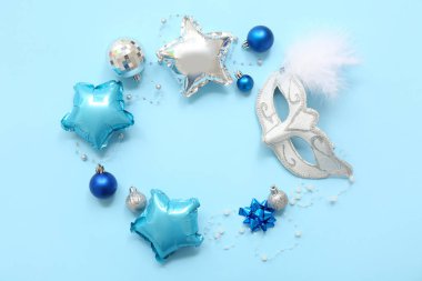 Karnaval maskesi ve mavi arka planda Noel dekorundan yapılmış çerçeve