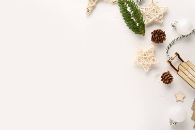 Beyaz arka planda çam kozalakları ve köknar ağacı dalıyla noel kompozisyonu