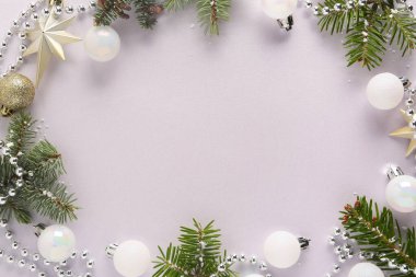 Köknar ağacı dallarından yapılmış çerçeve ve ışık arka planında Noel topları