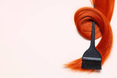Açık arkaplanda fırça ve kızıl saç teli, yakın plan.