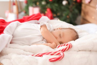 Noel arifesinde yatak odasında uyuyan şirin küçük bebek, yakın plan.