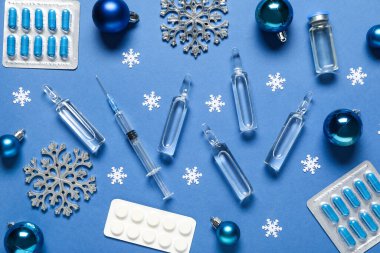 Farklı ilaçlara ve mavi arka planda Noel süslemelerine sahip kompozisyon
